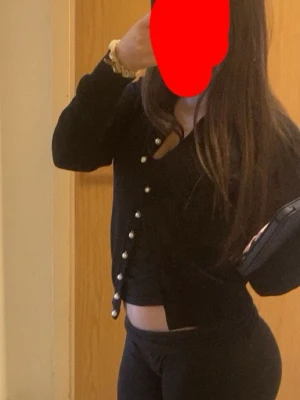 Svart kofta med pärlknappar - Snygg svart kofta med dekorativa pärlknappar framtill. Kortare modell med lång ärm och rund halsringning. Perfekt att styla över ett linne eller topp för en trendig look.