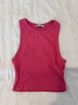 Rosa ribbat linne - Snygg rosa ribbad crop top från Zara med rund halsringning och ärmlös design. Perfekt för varma dagar eller att styla lager på lager. Mjuk och stretchig bomullskänsla som sitter tajt och bekvämt.