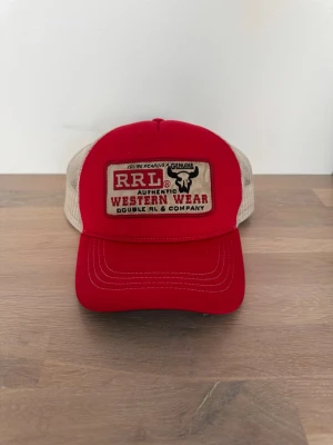 Röd RRL Trucker Foam Keps - Säljer en röd keps från Double RL/RRL/Ralph Ralph Lauren.  Den är inte mycket använd och i bra skick.  Den är justerbar på baksidan så den passar vem som helst.  Hör av dig vid frågor!