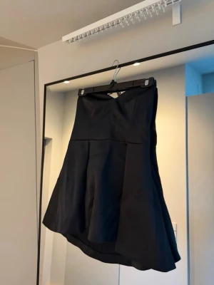 Svart axelbandslös topp - Säljer en svart axelbandslös topp. Aldrig använd. Nypris 800kr.