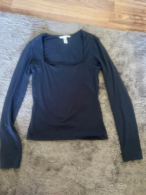 Mörkblå långärmad topp från H&M - Mörkblå långärmad tröja från H&M! Jättefin och skön tröja med fyrkantig urringning. Sitter snyggt på och är stretchig och bekväm. 💞Funkar både till vardags och om man vill klä upp sig lite. Bra skick, men finns ett litet hål i armhålan som är mycket lätt att sy!😊