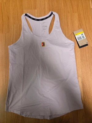 Nike lila linne, storlek S - Linne från Nike med Dri-FIT-teknologi och Slim Fit-passform. Designad med broderad logotyp framtill och Nike-text längs halsringningen.