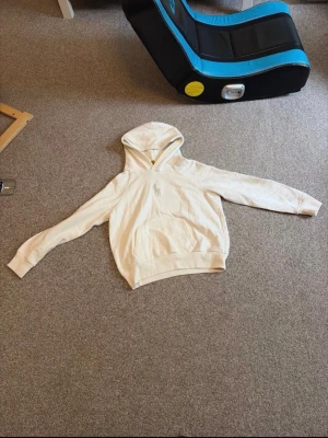Vit hoodie från Polo Ralph Lauren - Snygg vit hoodie från Polo Ralph Lauren med klassisk huva och känguruficka framtill. Diskret broderad logga på bröstet. Tillverkad i mjukt bomullsmaterial som känns skönt mot huden. Perfekt för en avslappnad och stilren look.