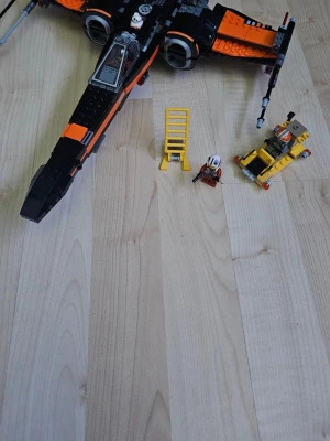 LEGO Star Wars X-Wing med figurer - Säljer en LEGO Star Wars X-Wing i svart och orange med 3 minifigurer, en gul stege och ett litet fordon. Byggsatsen har coola detaljer och rörliga delar, perfekt för dig som gillar Star Wars och LEGO.