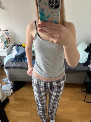 Rutiga pyjamasbyxor i bomull - Säljer ett par mysiga pyjamasbyxor med rutigt mönster i vitt, vinrött och gröngrå. Byxorna har resår i midjan och är raka i modellen, perfekta för chillkvällar hemma. Materialet känns mjukt och skönt mot huden. Knappt använda byxor som är otroligt sköna