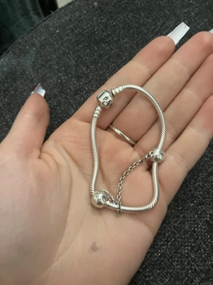 Silverfärgat Pandora armband - (Pris kan diskuteras)Snyggt silverfärgat armband från Pandora med ormkedja och två runda pärlor. Armbandet har klassisk Pandora-lås och är perfekt för att addera egna charms. Passar dig som gillar stilrena och personliga smycken.