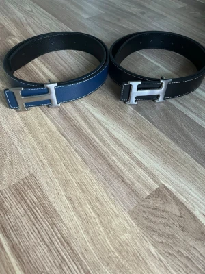 Två stycken H bälten - Du får två stycken H bälten där ena är marinblått och andra svart. Passar nästan alla och den är 105cm lång. Pris går att diskuteras vid snabb affär. Det går även att bara köpa en. Jag skickar inom 24h