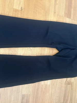 Svarta kostymbyxor från Lindex - Säljer ett par svarta kostymbyxor från Lindex i storlek 170. Byxorna har klassisk rak passform och stängs med knapp och dragkedja. Perfekta till en clean och stilren look.