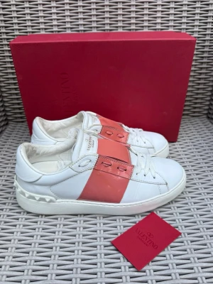Valentino vita sneakers med rosa detalj - Valentino Open || Storlek 37 || Skorna är i bra skick (se bilder) || Box och Valentino Kort medföljer || Tveka inte på att höra av dig vid frågor eller funderingar 