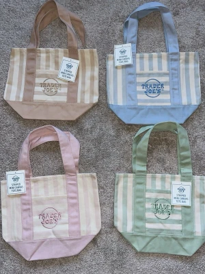 Randig mini shoppingväska Trader Joe's - Säljer 4 söta oanvända mini totebags från Trader Joe's i canvasmaterial. Väskan har breda handtag och finns i färgerna: beige, blå, rosa och grön. Perfekt för att bära småsaker och har broderad logga på framsidan. Materialet är en mix av bomull och polyester. Styckpris: 300kr💞