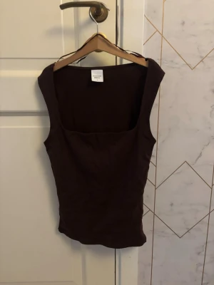 Vinröd  ärmlös linnetopp - Snygg vinröd linnetopp från ginatricot med fyrkantig ringning och ärmlös design. Perfekt att styla med jeans eller kjol för en trendig look. Toppens material känns mjukt och följsamt mot huden.