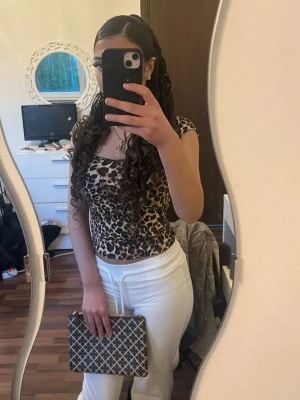 Leopardmönstrad croppad topp - Säljer en leopardmönstrad croppad topp med korta ärmar och rundad halsringning. Toppen har en tight passform och är perfekt för dig som vill sticka ut. Materialet känns mjukt och stretchigt, troligen polyester eller bomullsmix.