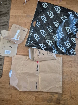 Förpacningar och påsar - Säljer ett gäng använda förpackningar och påsar i olika storlekar, bland annat från Lager157 och Amazon. Materialen är mestadels kartong och plast, färgerna är bruna och svart med tryck. Perfekt för dig som behöver extra emballage till frakt eller förvaring. Allt för 50kr.