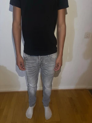 Grå Dsquared2 jeans  - Snygga grå slim fit jeans från Dsquared2 med slitna detaljer och klassisk femficksmodell. Jeansen har en diskret tvättad look och är tillverkade i mjuk denim med stretch för extra komfort.