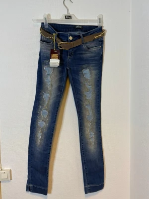 Blå skinny jeans med nitar från NVM - Midjan 36  cm  Längd 97  cm  Benvidd 23  cm 