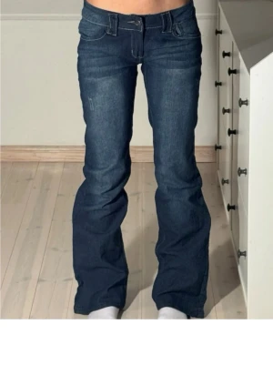 Mörkblå bootcut jeans med brodyr - Snygga mörkblå bootcut jeans med låg midja och dekorativ brodyr på bakfickan. De passa ikke. Kjøpt totalt for 586 kr