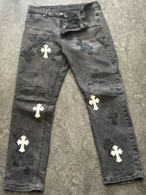 Chrome Hearts Grå jeans - Ser svarta ut men det är för att det är dåligt ljus, är gråa egentligen. Vilket i sig gör dom otroligt speciella. Super häftiga kors mönster och allt. Läder tag på insidan. Super häftig modell. Pris går att diskutera. Hör av dig så får du se passformen.