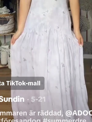 Ljuslila långklänning med blommor💜 - Romantisk långklänning i ljuslila med små blommiga detaljer och v-ringning. Klänningen har ärmlös design och ett luftigt, svepande fall som ger en bohemisk känsla. Perfekt för varma dagar och sommarens alla tillfällen. Helt ny och oanvänd med lappen kvar, 1700kr i nypris så därav priset💜💜💜