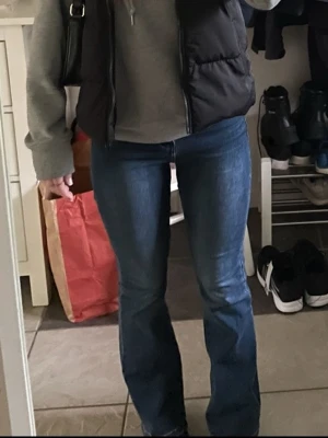 Blå bootcut jeans från Denim - Säljer ett par blå bootcut jeans från Denim med klassisk femficksmodell och lätt slitna detaljer framtill. Jeansen har normal midja och är tillverkade i ett stretchigt denimtyg för skön passform. Perfekta till sneakers eller boots! Sitter superbra, ej bra pris,,, skriv till mig