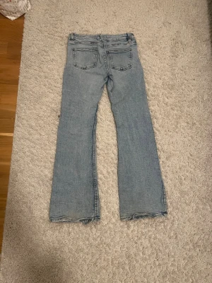 Ljusblå bootcut jeans Gina Tricot - Säljer ett par ljus inter collab bootcut jeans från Gina Tricot. Jeansen har klass mar bakfickor, rejäla sömmar och råa kanter vid bensluten för en avslapp earning bio. Perfekta för dig som gillar en retro och sopig look.