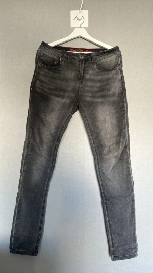 Gråa jeans - Snygga grå slim fit jeans från Blue Monkey med lätt tvättad look. Klassisk femficksmodell med knapp och dragkedja framtill. Jeansen har en smal passform och är tillverkade i stretchigt denimtyg för extra komfort.