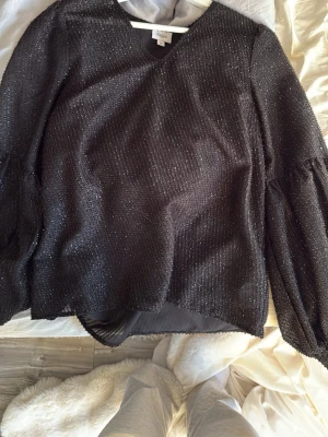 Glittrig blus  - Säljer denna super fina svarta glittriga blusen från saint tropez, knappt använt så mycket bra skick, stl xs. 