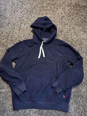 Mörkblå hoodie från Polo Ralph Lauren - Snygg mörkblå ovanlig fleece hoodie från Polo Ralph Lauren. Storleken är S men sitter något mindre