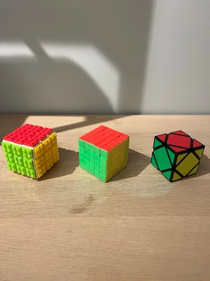 Tre olika Rubiks kuber och twist-pussel - Säljer tre olika kubpussel: en klassisk Rubiks kub med taktil yta i rött, gult, grönt och blått, en 5x5 Rubiks kub i färgerna röd, grön, gul, blå, vit och orange samt ett twist-pussel med svarta kanter och färgade sidor i rött, grönt, gult och blått. Jätte bra skick, snabb leverans och snabba svar!✅ 
