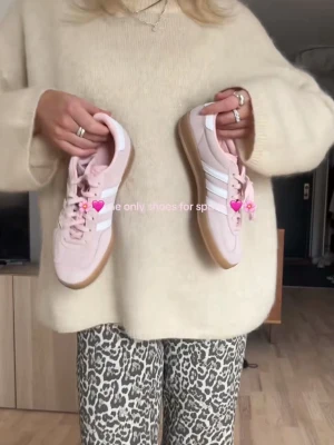 Adidas Gazelle rosa sneakers - Snygga Adidas Gazelle sneakers i ljusrosa mocka med vita klassiska ränder på sidorna och gummisula. Låg modell med snörning och diskret gulddetalj vid sidan. Perfekta för en trendig och avslappnad stil. Använda ca 3 gånger. Storlek 39 o 1/3! Säljer för 800kr