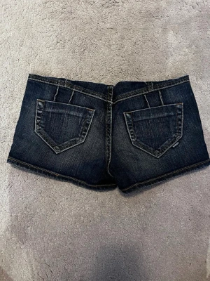 Mörkblåa jeansshorts - Säljer ett par mörkblåa jeansshorts i storlek xxs. Klippte dem så att de blev mer lågmidjat, så de har gått upp lite vid knappen❤️