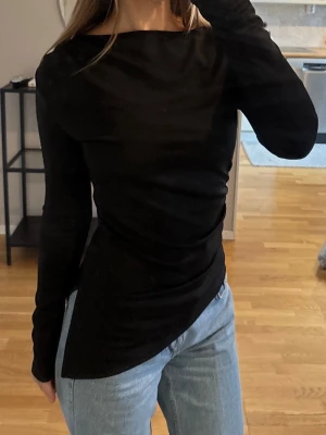 Oanvänd svart asymmetrisk topp från ginatricot - Oanvänd svart långärmad topp från ginatricot asymmetrisk. lapp kvar 