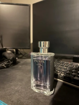 Prada Milano herrparfym - Snygg parfymflaska från Prada Milano med elegant och stilren design. Flaskan är genomskinlig med silverfärgad kork och svarta detaljer på sidorna. Perfekt för dig som gillar exklusiva dofter och vill ha något lyxigt på hyllan. Använd kanske 10 sprut. Box finns med. Pris kan diskuteras