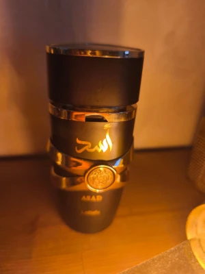 Lattafa Asad parfym svart/guld - Själv parfymen är i bra skick men flaskan är skadad får när jag beställde den. Det går att speja, enda felen är att det är vissa sprickor och hål i plasten. Kom med förslag på pris eller byten