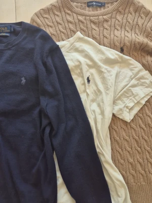 Ralph Lauren tröjor och t-shirt - Två snygga ralph lauren tröjor, en I hely nytt skick st M, den andra i bra skick förutom ett litet hål se bild st S funkar på M                                                      T-shirten är i okej skick st S