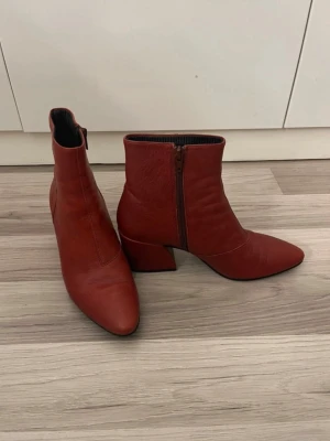  stövletter med klack - Snygga  stövletter med markerad blockklack och spetsig tå. Dragkedja på insidan för enkel på- och avtagning. Stövletterna har en stilren design.
