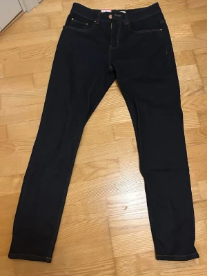 Nya Revolution mörkblå straight fit jeans nypris 999 - Helt nya snygga mörkblå straight fit jeans från Revolution. Nypris 999. Jeansen har kontrastsömmar och raka ben. Perfekta för en trendig och enkel look. Materialet är troligtvis bomull med stretch för extra komfort. 