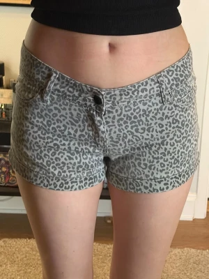 Grå leopardmönstrade shorts Carlings - Snygga grå shorts från R&D med leopardmönster. Modellen har normal passform, klassisk femficksdesign och knappgylf. Perfekta för dig som vill sticka ut lite extra i sommar.
