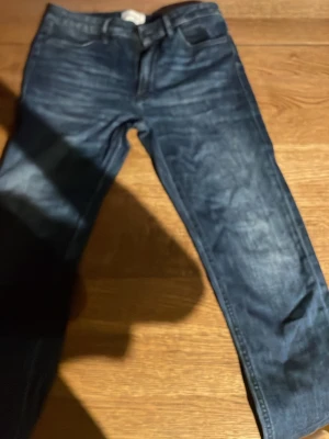 Mörkblå jeans från Dondup - Säljer ett par mörkblå jeans från Dondup, modell IRIS. Jeansen har klassisk femficksdesign, normal midja och raka ben. Tillverkade i denim med snygga slitningar och tvättade detaljer för en cool look.
