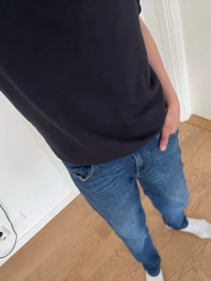 Blå jeans från Jack & Jones - Säljer ett par klassiska blå jeans från Jack & Jones. Jeansen har normal passform, fem fickor och snygga kontrastsömmar. Perfekta till vardagslooken och lätta att matcha med olika stilar.