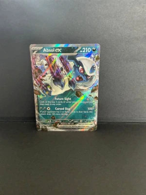 Pokémonkort Absol EX 210 HP - Säljer ett holografiskt Pokémonkort av Absol EX med 210 HP. Kortet har färgstark design med blå, vit och lila ton samt coola attacker som Future Sight och Cursed Slug. Perfekt för samlare eller dig som vill boosta din lek med en kraftfull EX.