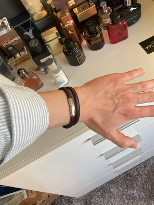 Läderarmband Scottsberry - Stiligt mörkbrunt läderarmband ifrån Scottsberry. Helt nytt och säljs då jag fick två stycken i studentpresent. Passar handleder med omkrets ca 15-17 cm, sitter säkert lika fint på 14 och 18cm också.