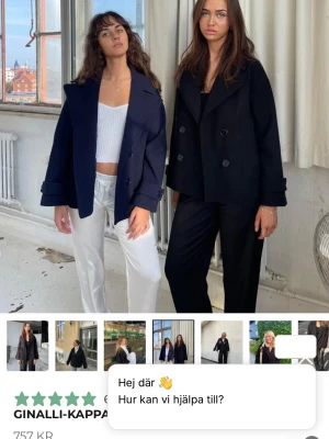 Svart dubbelknäppt kappa Design S - Stilren svart kappa från Design S i storlek XS/S. Modellen är dubbelknäppt med bred krage och raka ärmar. Kappan har en boxig, croppad passform och är tillverkad i ett tjockare tyg som passar perfekt till kyligare dagar. Pris får självklart att diskutera 