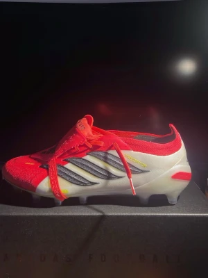 Adidas Predator fotbollsskor röd/vit - Snygga Adidas Predator fotbollsskor i rött och vitt med svarta detaljer. Använda en gång på konstgräs därför lite svart på dubbarna. Men inte alls slitna skor utan är som nya. Passa inte mina fötter och behöver ny ägare. Köpt för 3299 men säljer för 1749!