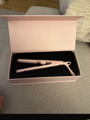 Rosa mini plattång i presentask - Snygg och smidig mini plattång i ljusrosa färg, levereras i matchande presentask. Perfekt storlek för att ta med i väskan. Plattången har sladd och är tillverkad i plast och metall.