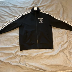 Moschino zip hoodie  - Moschino tröja den är köpt på Nk i Göteborg, 100% äkta! cond 10/10, strl:46/M, Nypris 6299kr, Kvitto finns men syns inte tydligt skorv om ni vill ha bild på det. Pris kan gå att diskutera vid snabb affär. Hör av er vid frågor eller funderingar//Daahlgren.resell☺️