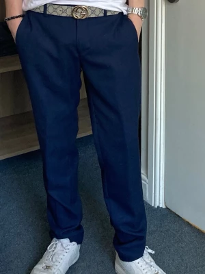 Mörkblå kostymbyxor samt snygg tröja i grått - Snygga mörkblå kostymbyxor i slim-fit modell och klassisk design i storlek 36. Byxorna har pressveck och sidfickor, perfekta för en stilren look. Materialet känns mjukt och följsamt, vilket gör dem bekväma att bära hela dagen. Samt en grå snygg zip-tröja från Jack & Jones i storlek XS. 