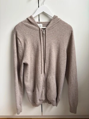 Beige zip-hoodie cashmere  - Säljer en beige hoodie från John Henric med dragkedja och huva. Tröjan är tillverkad i cashmere.