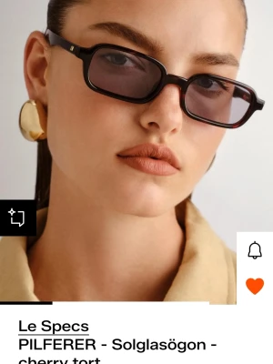Le Specs smala solglasögon brun - Trendiga smala solglasögon från Le Specs i modellen PILFERER. Glasögonen har rektangulära linser med mörktonade glas och brunmelerad båge. Perfekt accessoar för en cool och modern look.