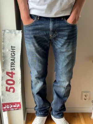 Levis 504 Straight Vintage Jeans - Levis 504 straight. Rak passform. Väldigt schyssta vintage jeans. Skick: A Grade, perfekt skick!  Färg: Mörkblå med fades | Modell: 504 Straight | Storlek: W33 L34 | Premium Jeans. Passar bra på killen i bilden som är 189 cm.   Mått: (Måttavvikelse +-1cm) Midja: 42,5 cm Längd: 110 cm Benslut: 20 cm Lår (från grenen): 30 cm  Tveka inte att höra av dig minsta fråga eller fundering!  Skickas snabbt!
