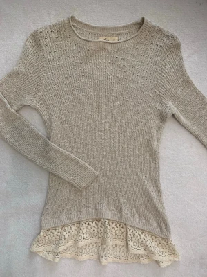 Hollister beige stickad tröja med spetsdetalj strl S - Fin beige stickad tröja från Hollister i storlek S 🤍 Söt och feminin modell med spets-/volangdetalj nertill 